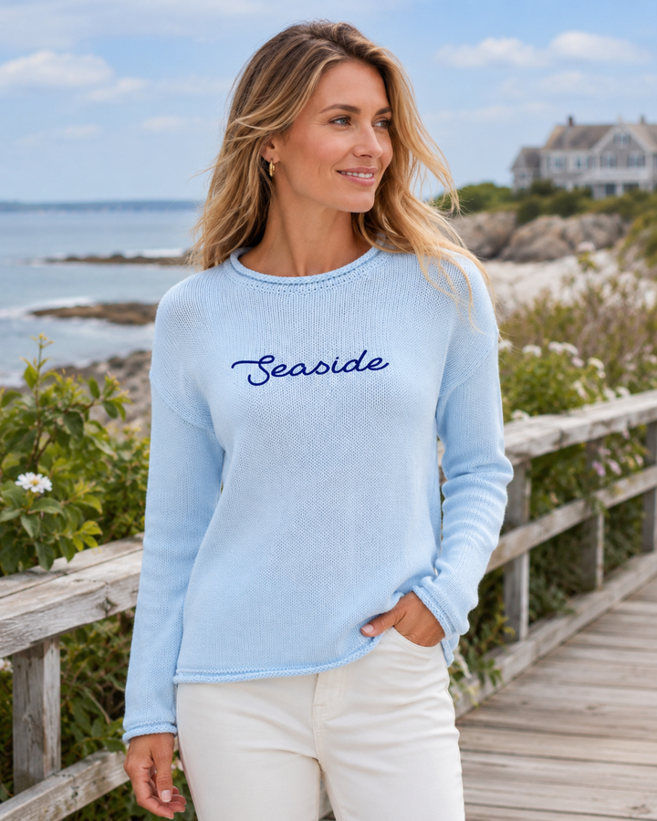 Woman wearing a light blue sweater with &